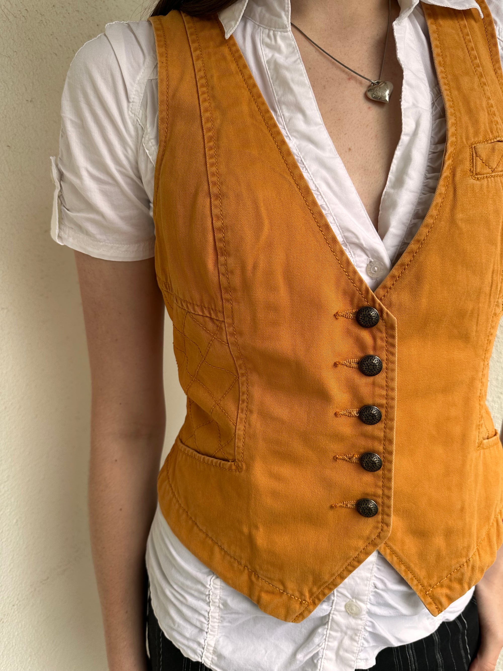 Woman wearing a Y2K 00s Rusty orange waistcoat with a fitted, tailored shape and stitching detail
