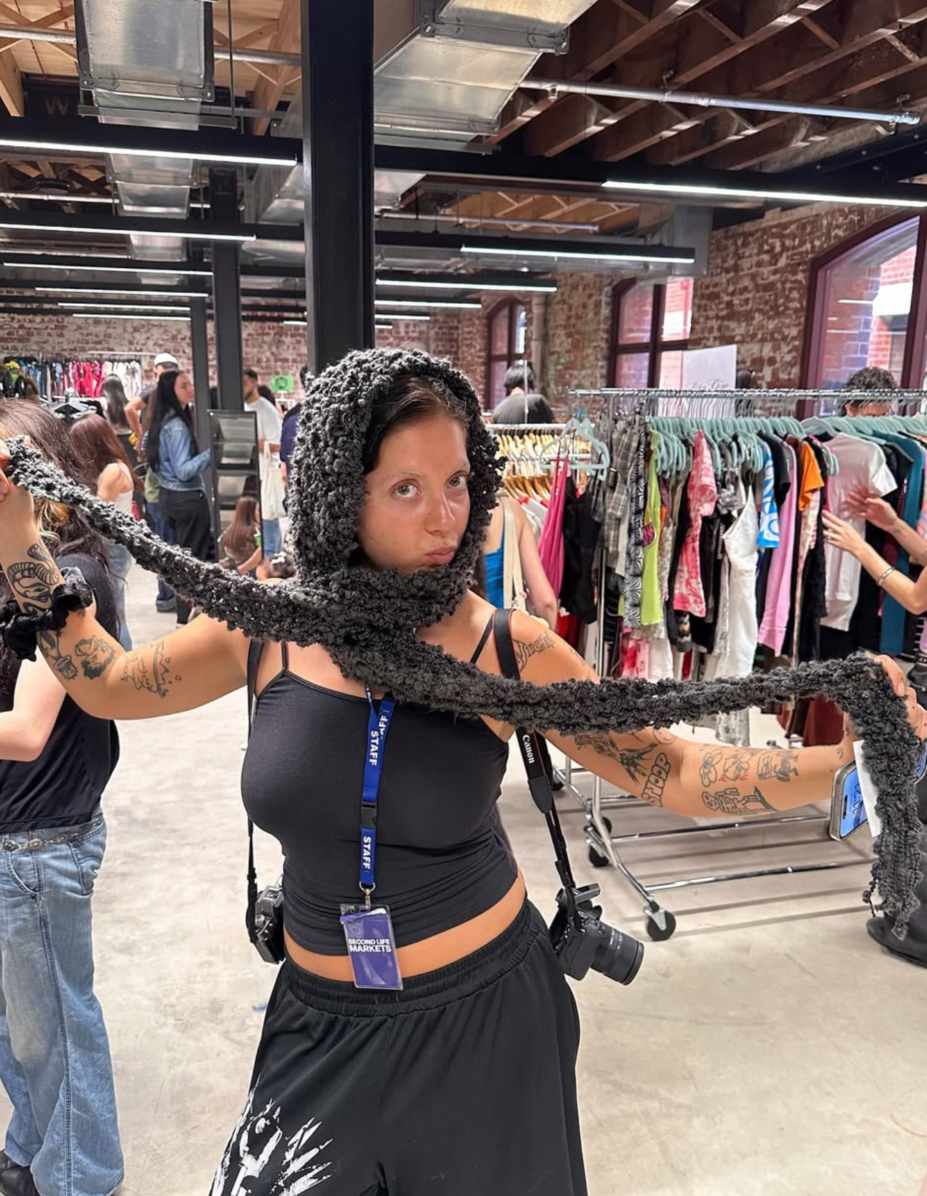 Person wearing a textured black hood in a clothing store