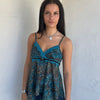 Woman Dressed in Y2K 00s Teal and brown sparkle paisley boho top featuring shimmer pieces all over for a subtle fairy-like glow.