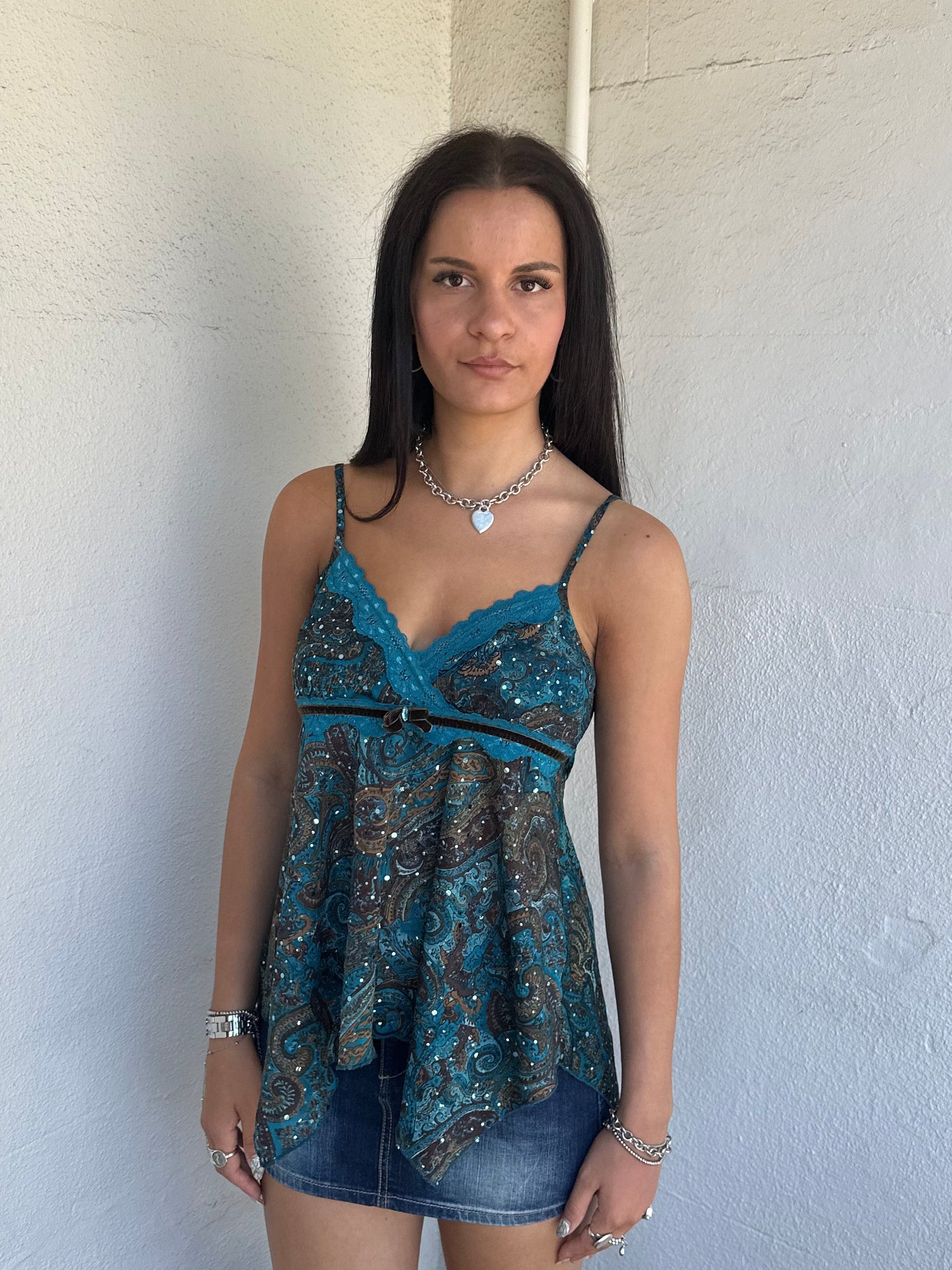 Woman Dressed in Y2K 00s Teal and brown sparkle paisley boho top featuring shimmer pieces all over for a subtle fairy-like glow.