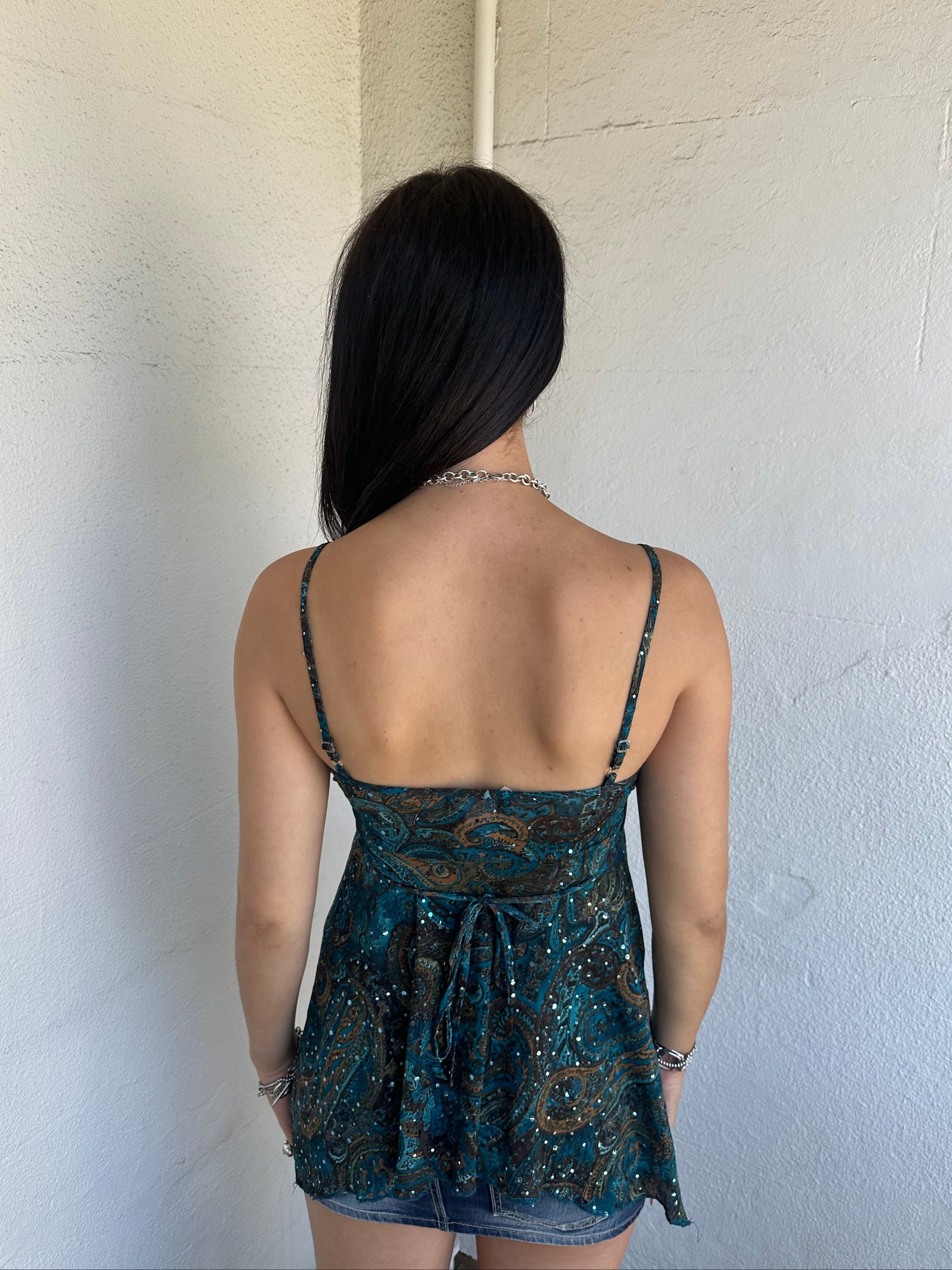 Woman Dressed in Y2K 00s Teal and brown sparkle paisley boho top featuring shimmer pieces all over for a subtle fairy-like glow.