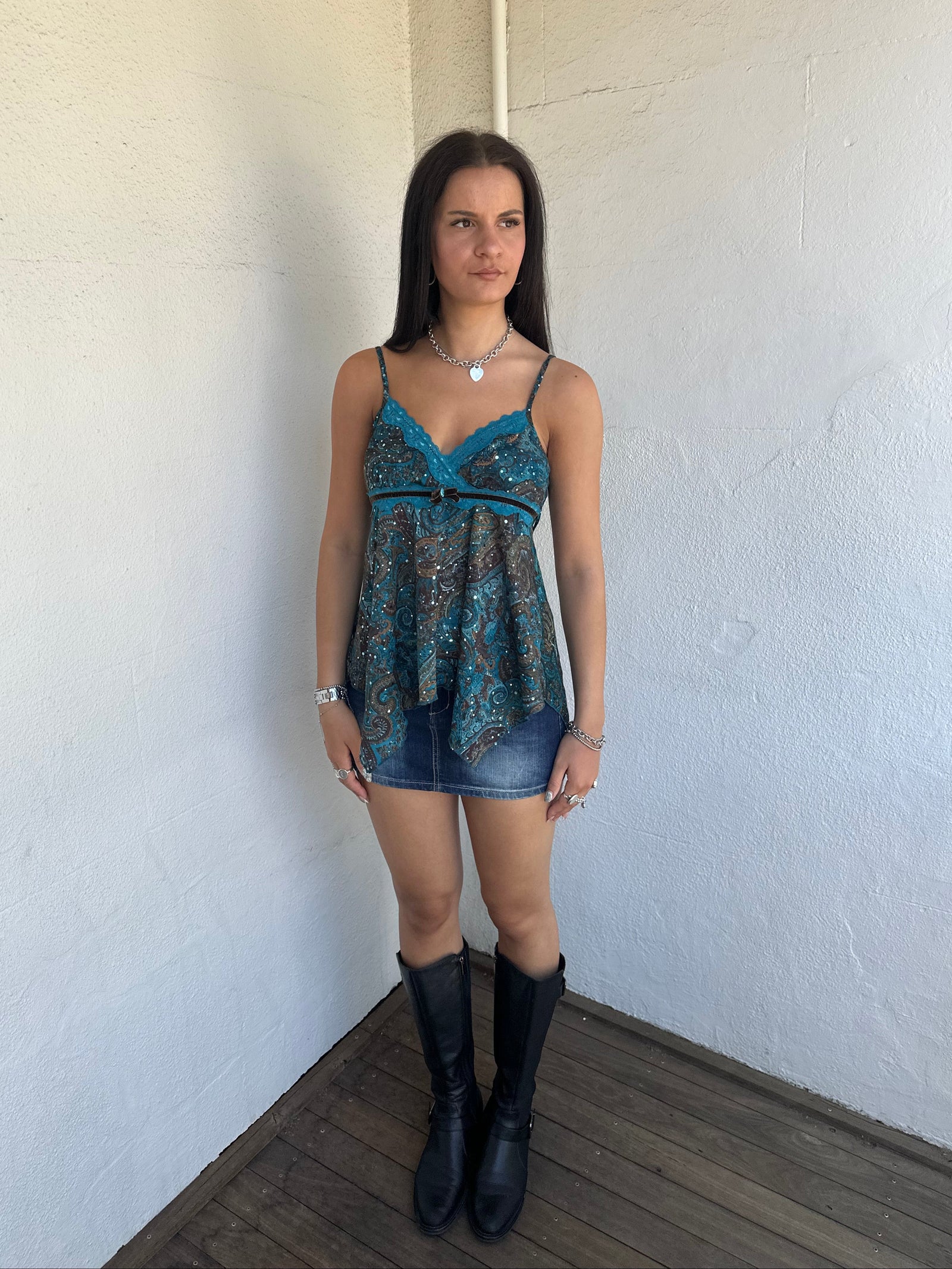 Woman Dressed in Y2K 00s Teal and brown sparkle paisley boho top featuring shimmer pieces all over for a subtle fairy-like glow.