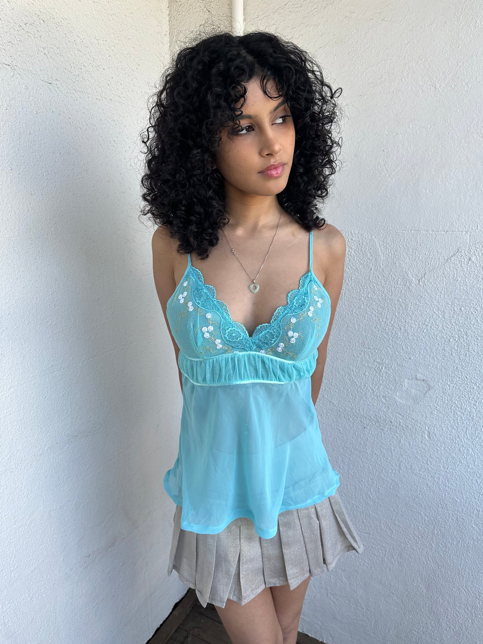 Women wearing a 00s Y2K Turquoise embroidered fairy cami with a lace bust featuring white and gold floral embroidery. 