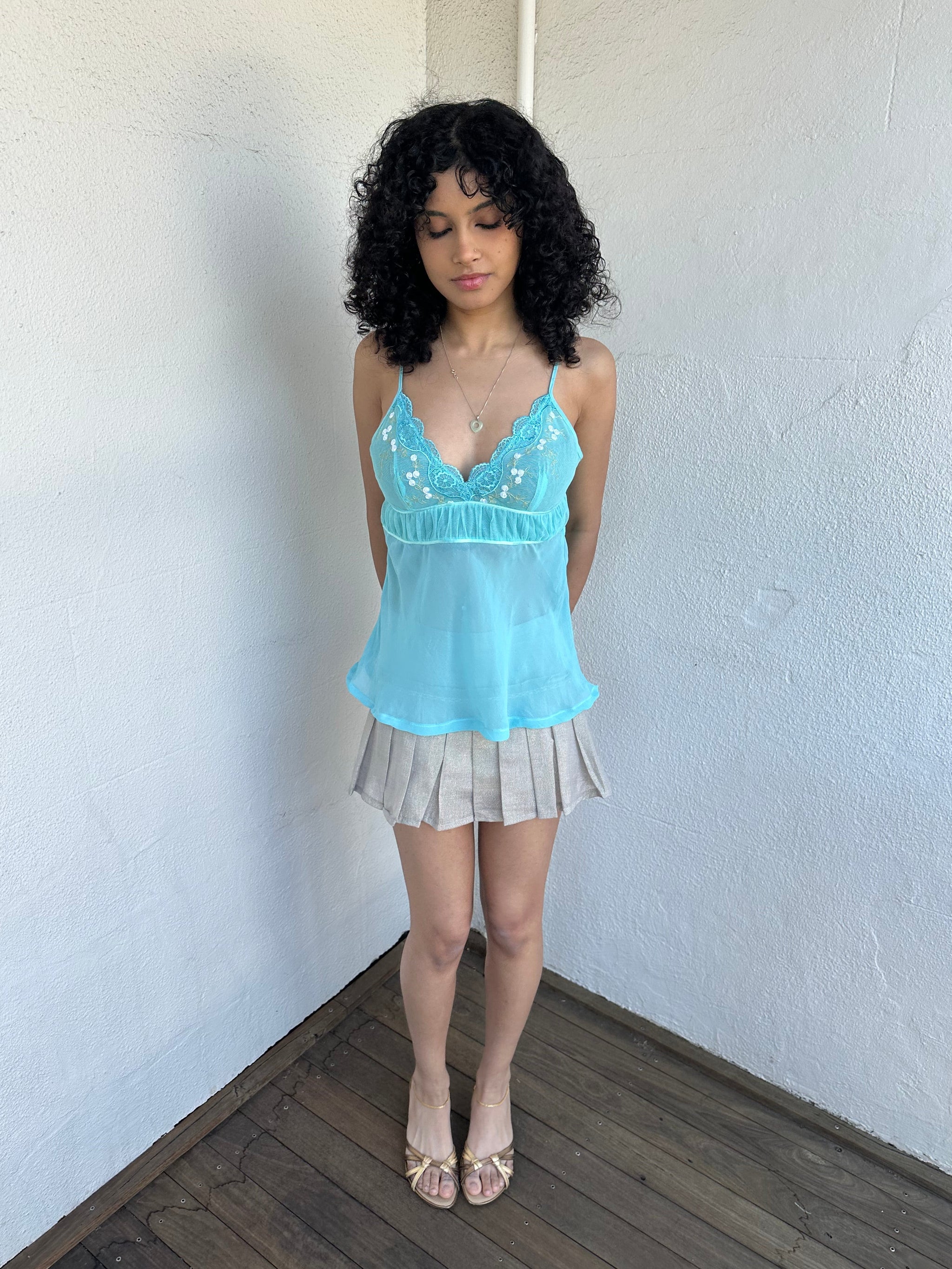Women wearing a 00s Y2K Turquoise embroidered fairy cami with a lace bust featuring white and gold floral embroidery. 