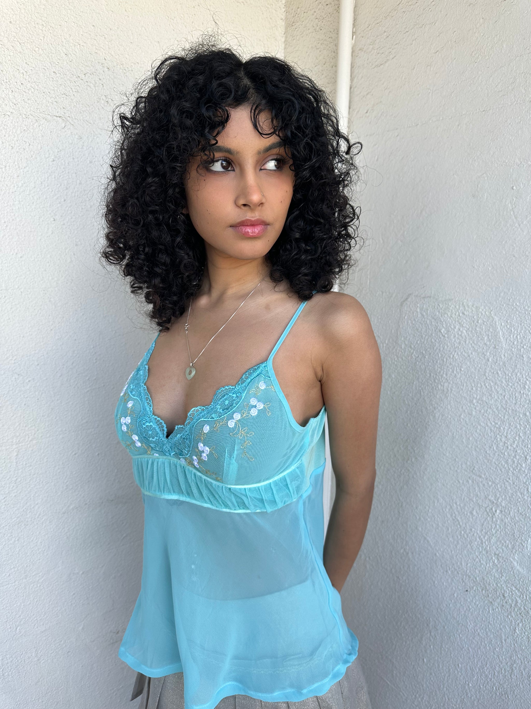 Women wearing a 00s Y2K Turquoise embroidered fairy cami with a lace bust featuring white and gold floral embroidery. 