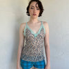 Woman Dressed in Y2K Green stripe knitted tank top featuring alternating horizontal stripes in pastel green and lime green 