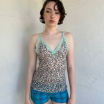 Woman Dressed in Y2K Green stripe knitted tank top featuring alternating horizontal stripes in pastel green and lime green 