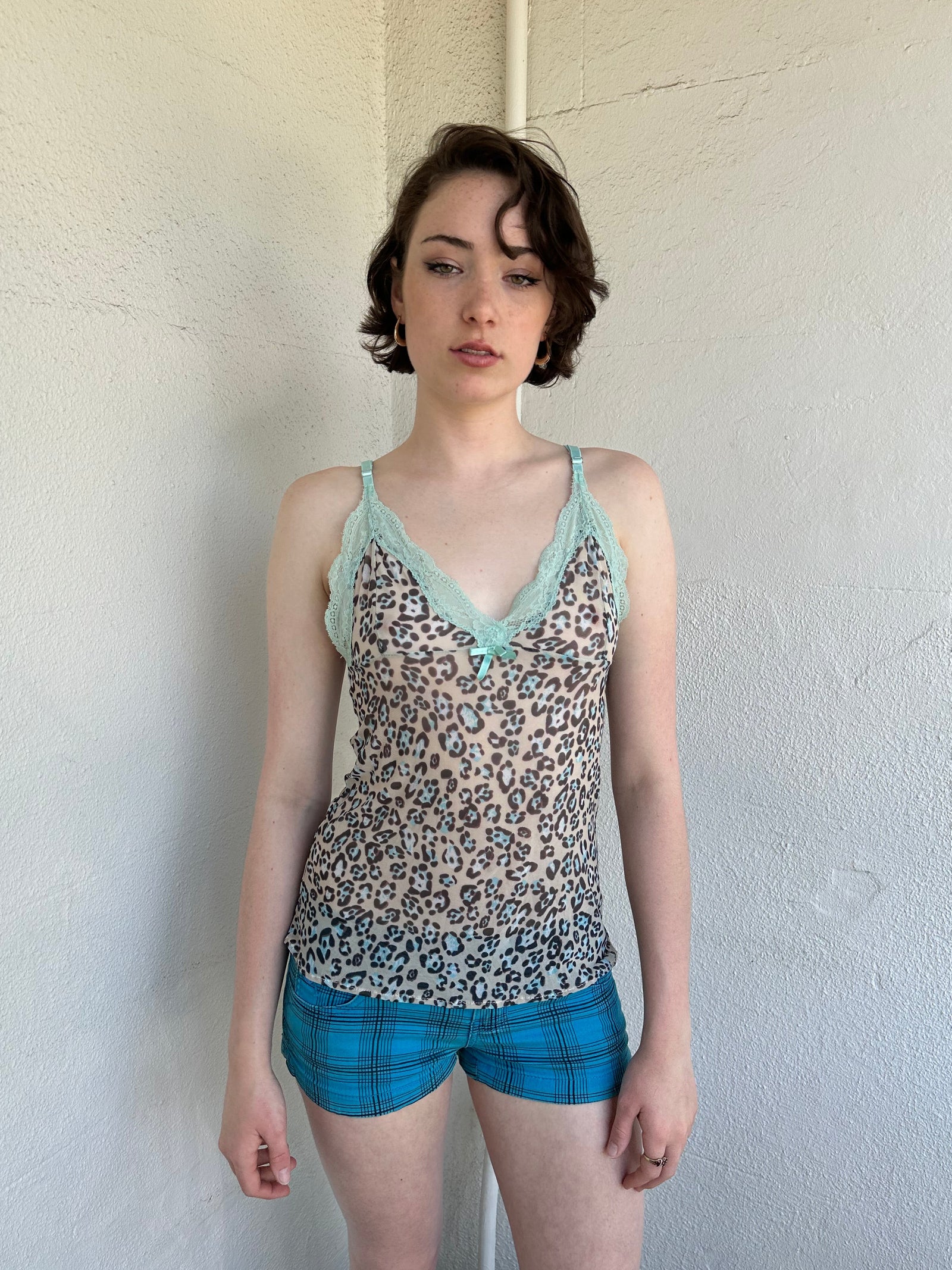 Woman Dressed in Y2K Green stripe knitted tank top featuring alternating horizontal stripes in pastel green and lime green 