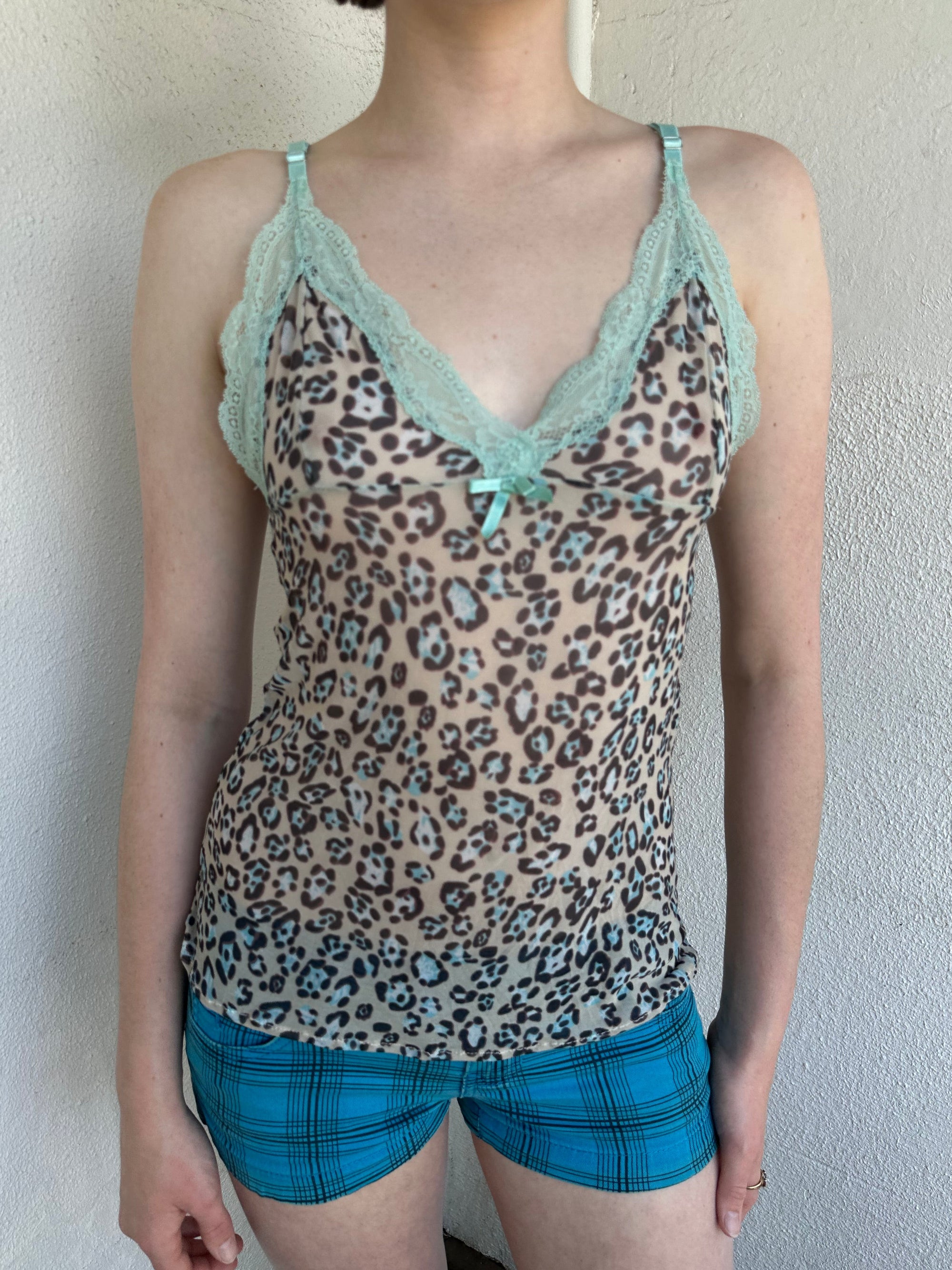 Woman Dressed in Y2K Green stripe knitted tank top featuring alternating horizontal stripes in pastel green and lime green 