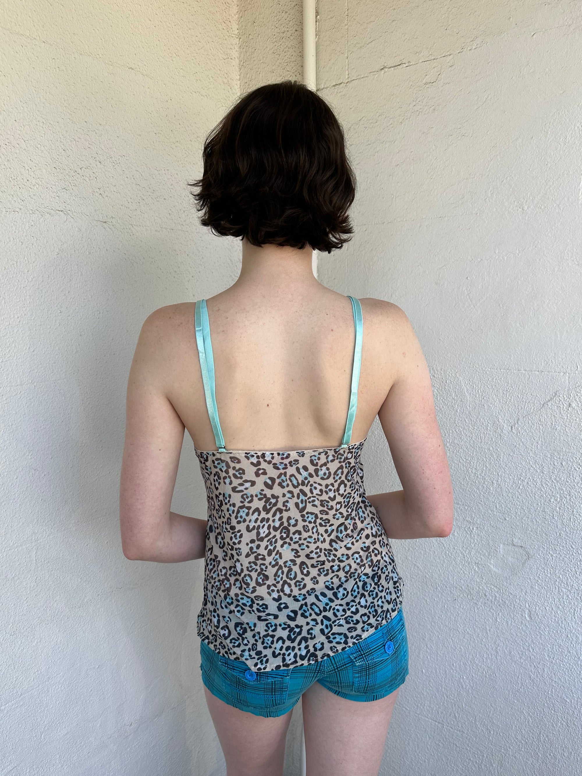 Woman Dressed in Y2K Green stripe knitted tank top featuring alternating horizontal stripes in pastel green and lime green 