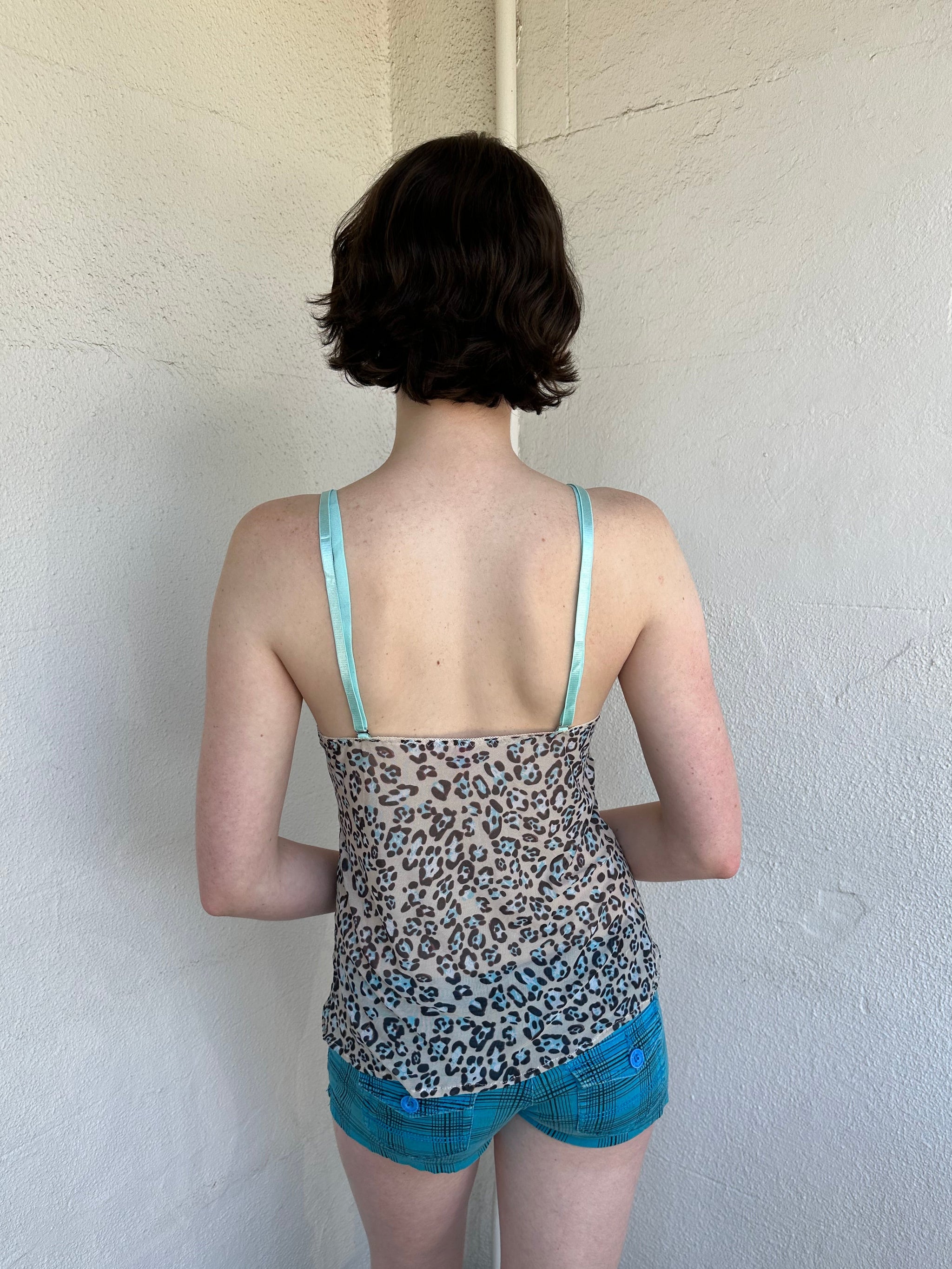 Woman Dressed in Y2K Green stripe knitted tank top featuring alternating horizontal stripes in pastel green and lime green 