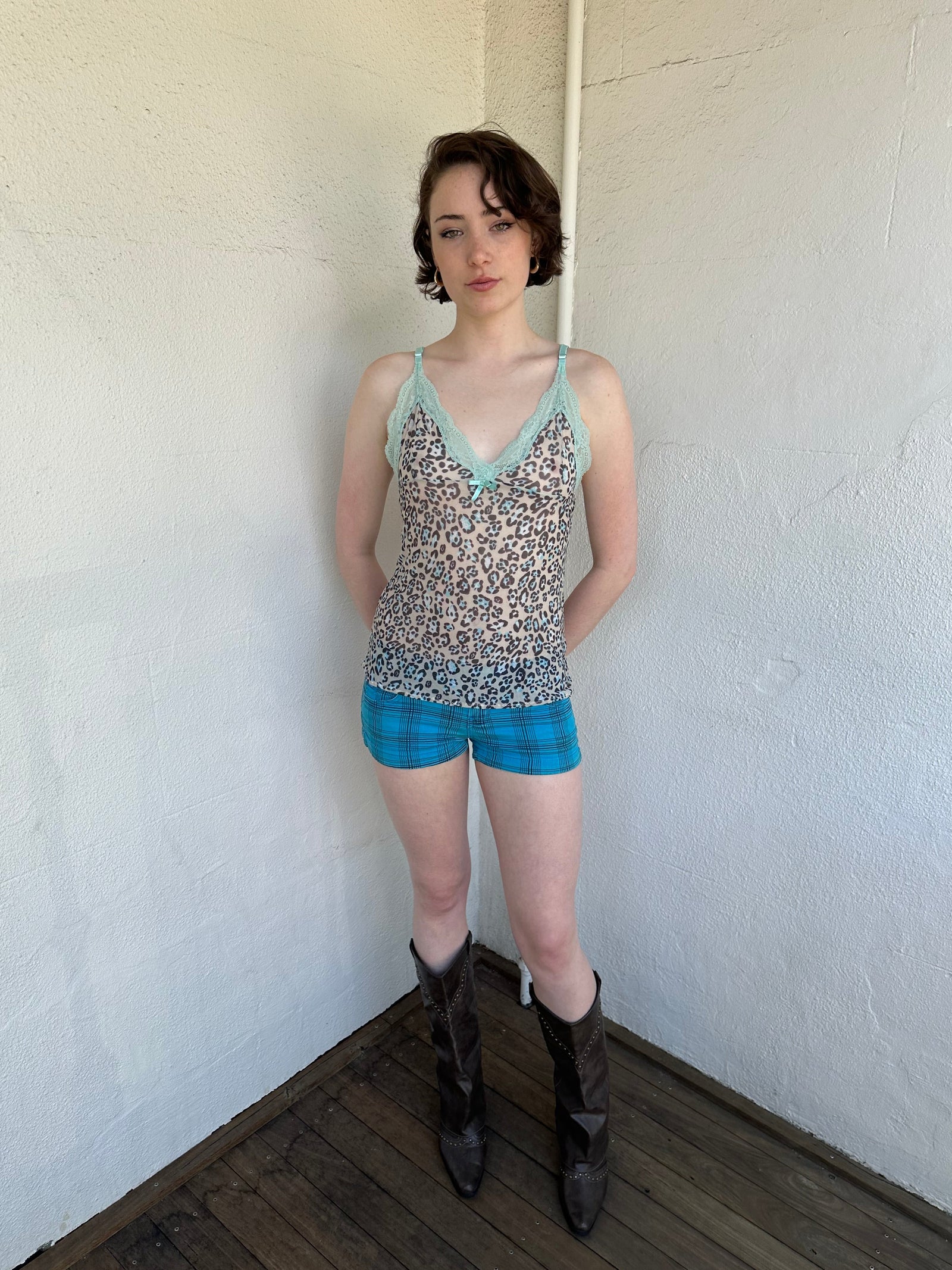 Woman Dressed in Y2K Green stripe knitted tank top featuring alternating horizontal stripes in pastel green and lime green 