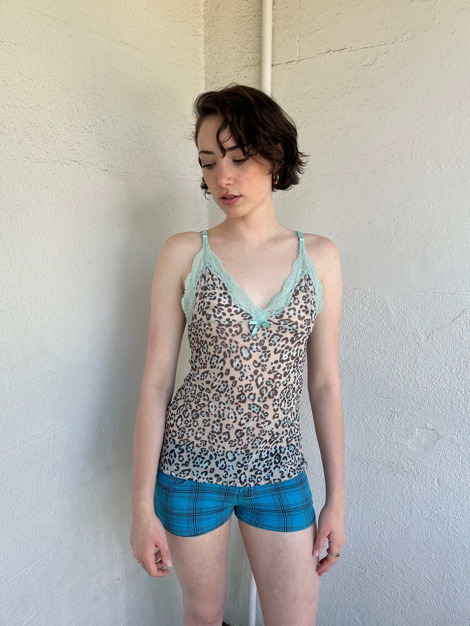 Woman Dressed in Y2K Green stripe knitted tank top featuring alternating horizontal stripes in pastel green and lime green 