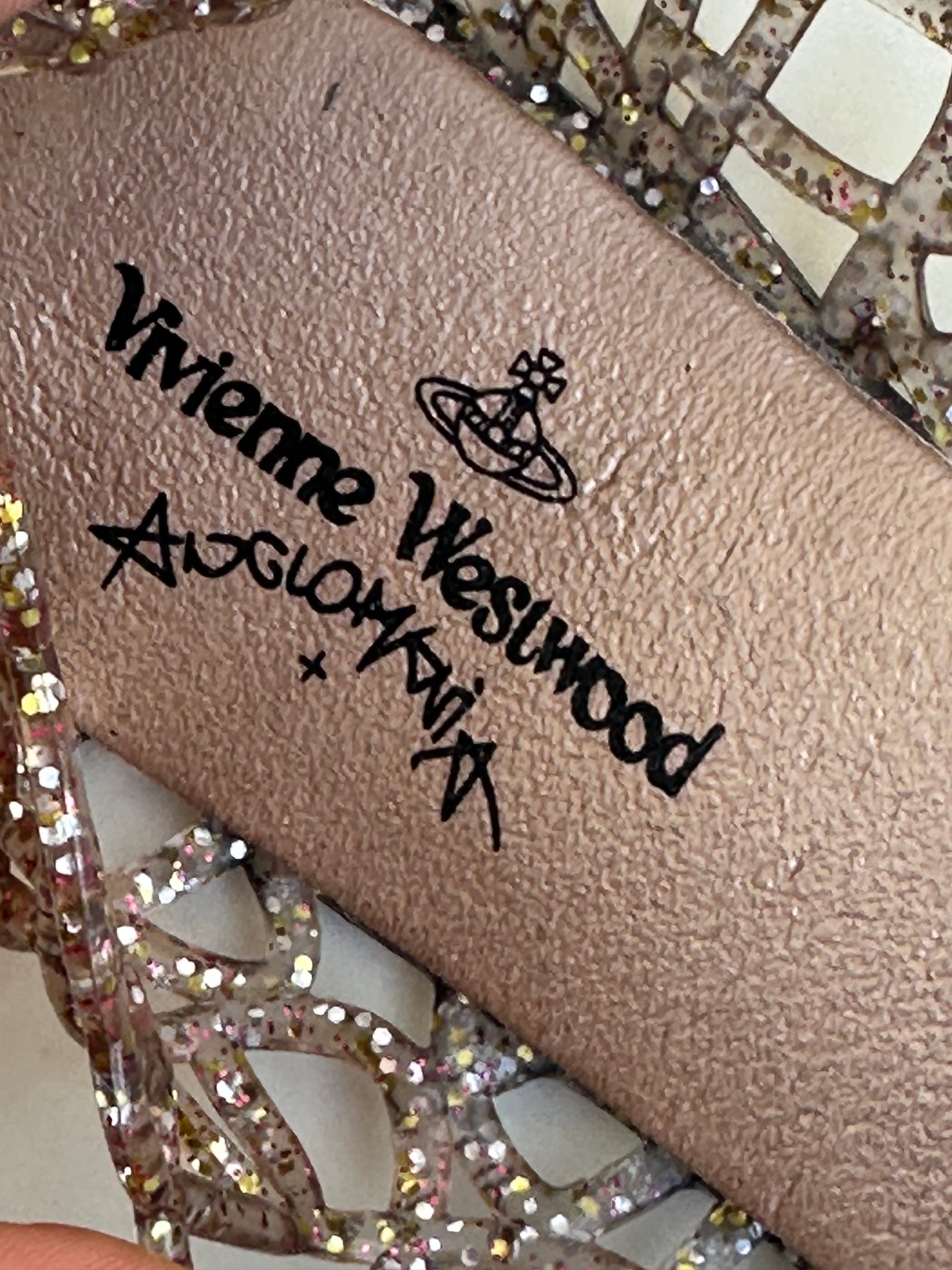 Woman wearing a Y2K 90s Vivienne Westwood X Anglomania jelly ballet flats in a netted clear glitter style.