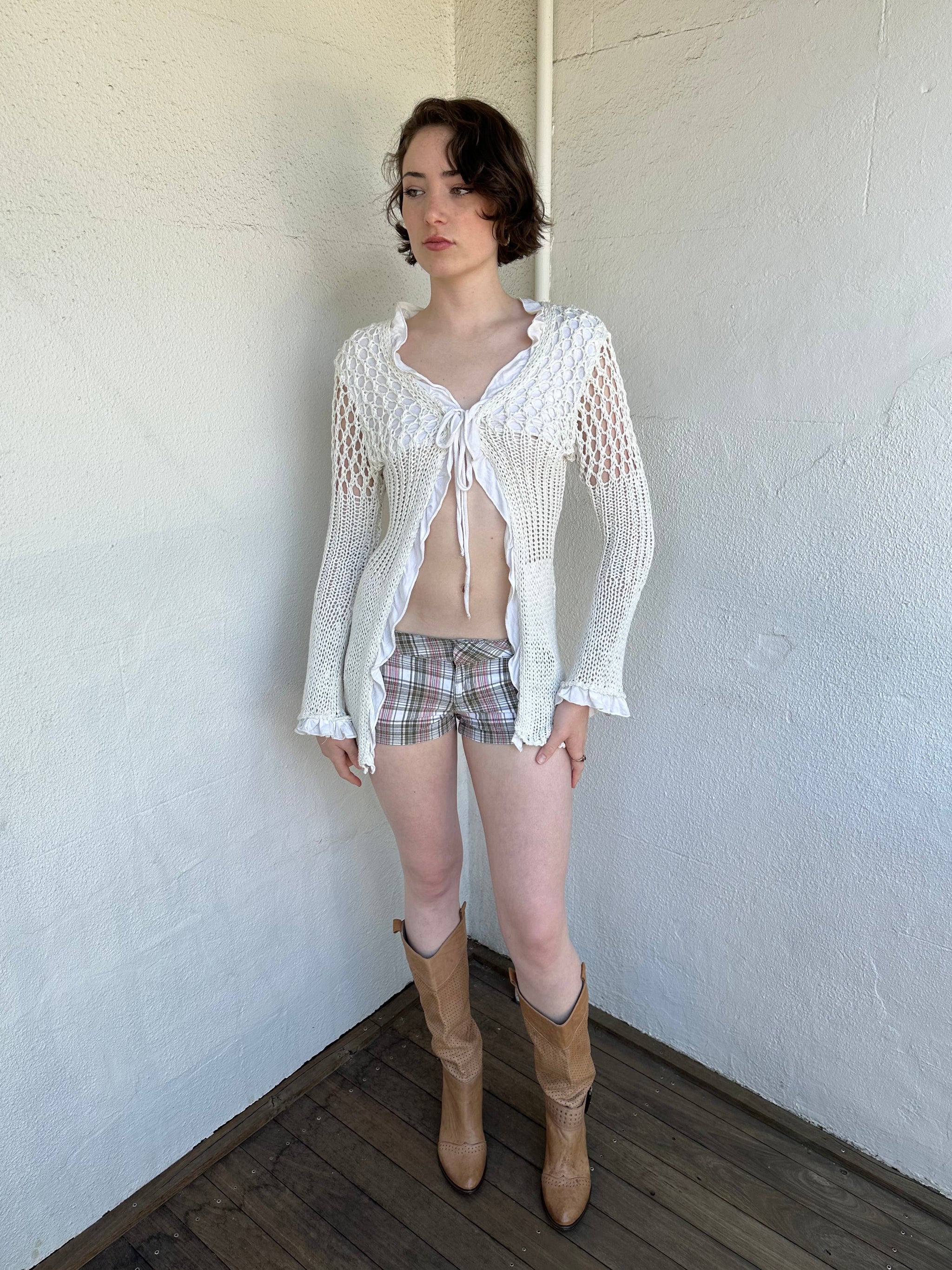 Woman Dressed in Y2K White crochet tie front cardigan featuring a layered bust design