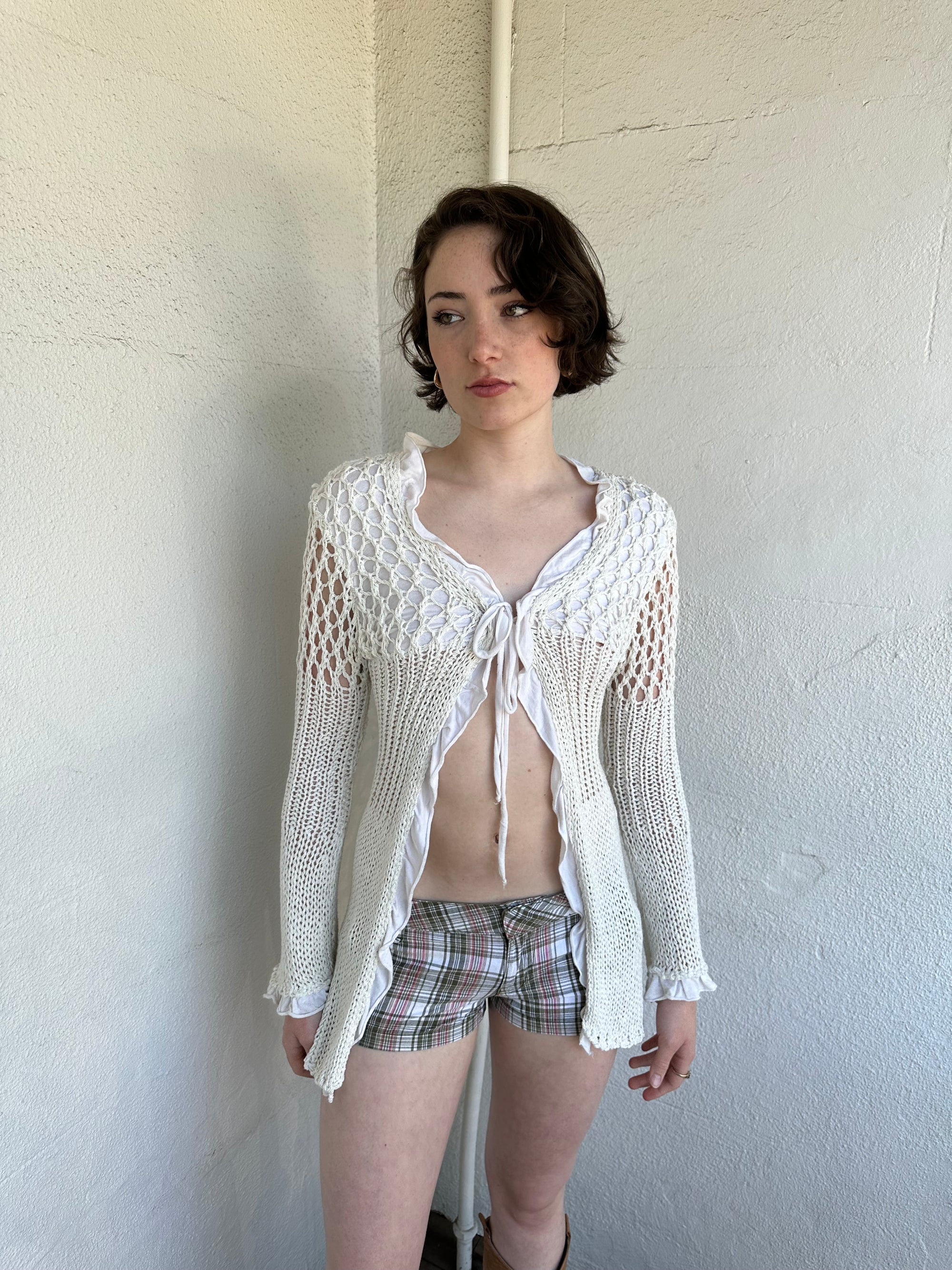 Woman Dressed in Y2K White crochet tie front cardigan featuring a layered bust design