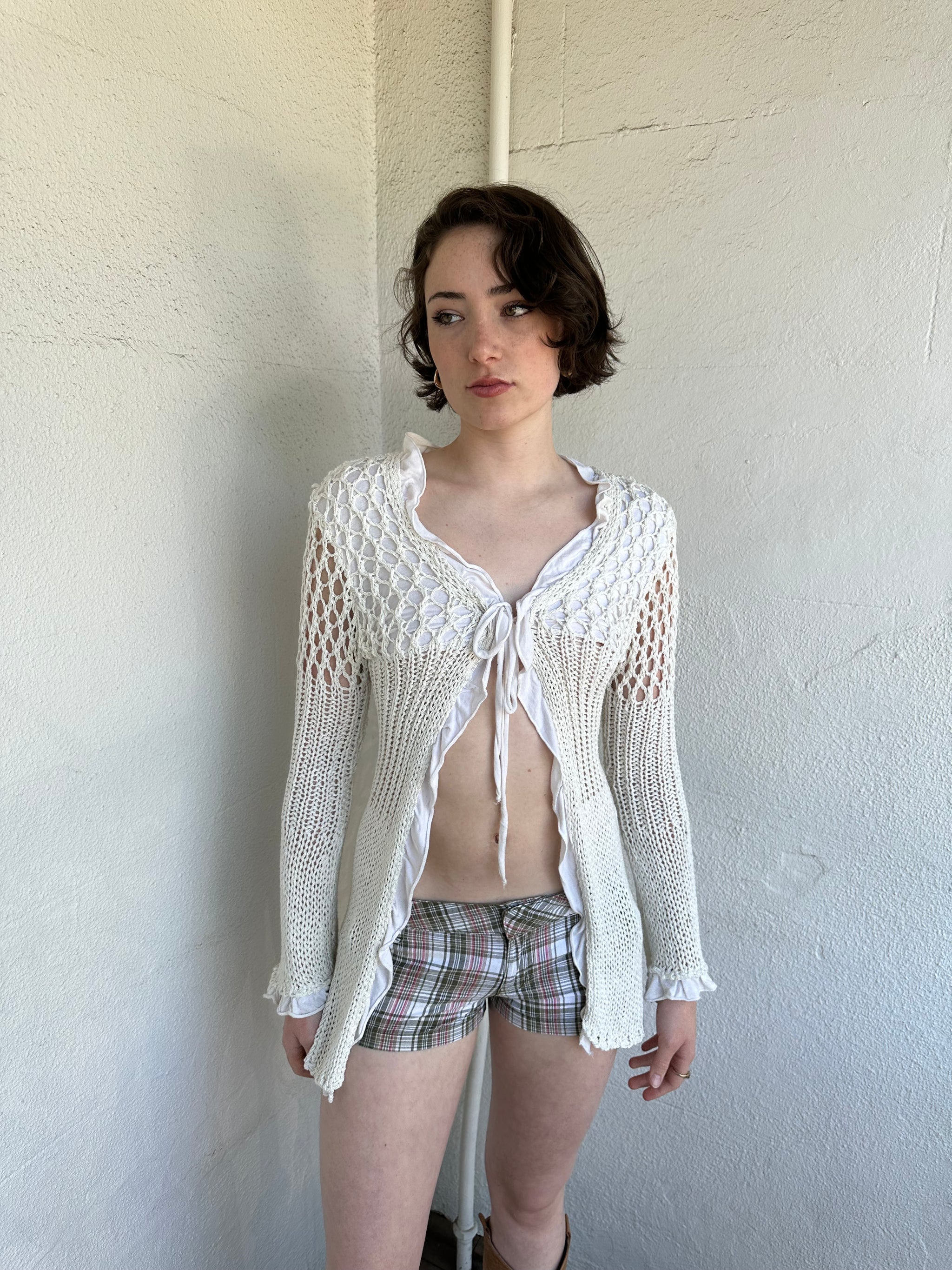 Woman Dressed in Y2K White crochet tie front cardigan featuring a layered bust design