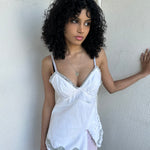 Woman wearing a Y2K 90s White denim fitted cami top with grey lace trim and a small patch pocket on the back sized for a flip phone! 