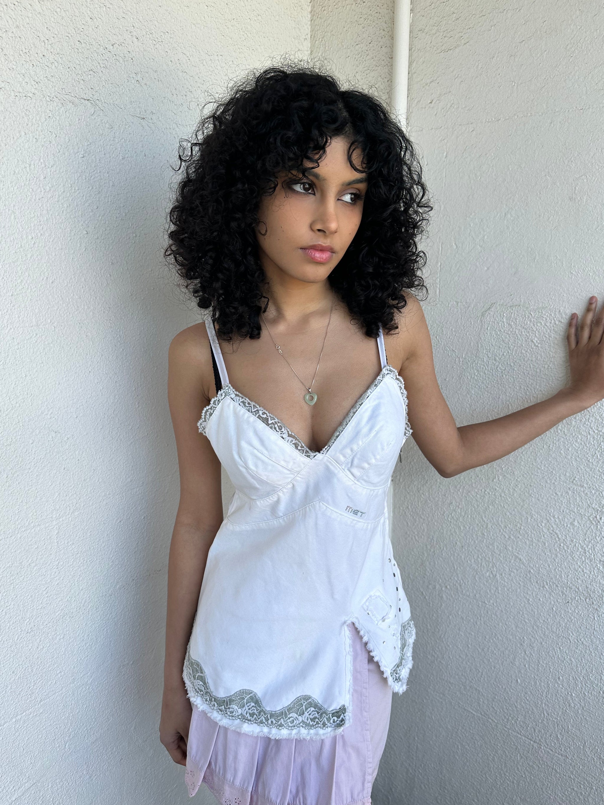 Woman wearing a Y2K 90s White denim fitted cami top with grey lace trim and a small patch pocket on the back sized for a flip phone! 