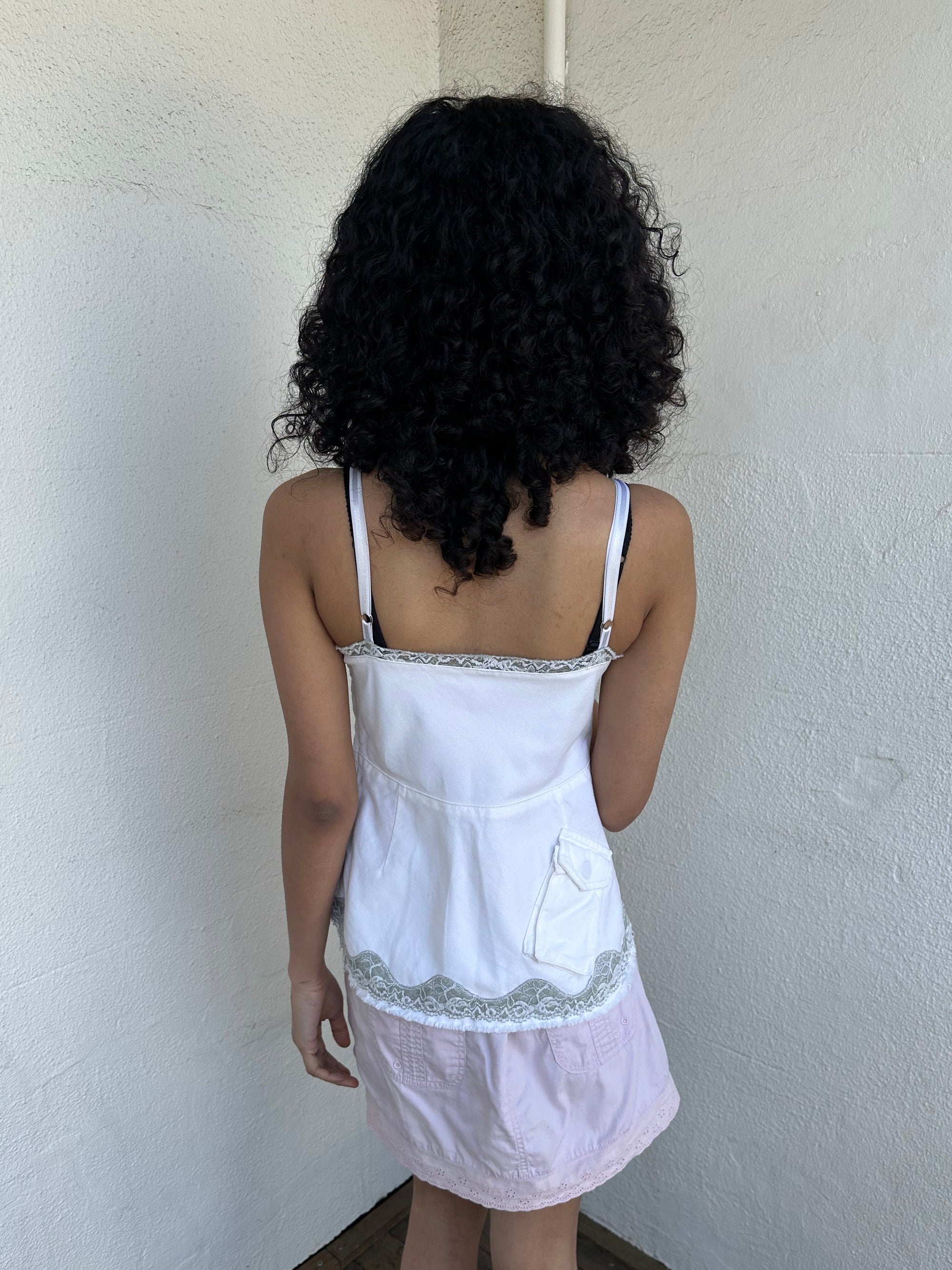 Woman wearing a Y2K 90s White denim fitted cami top with grey lace trim and a small patch pocket on the back sized for a flip phone! 