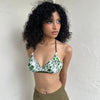 Woman Dressed in Y2K 00s White and green floral bikini top with a white base and green and khaki floral print throughout.