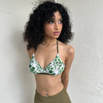 Woman Dressed in Y2K 00s White and green floral bikini top with a white base and green and khaki floral print throughout.