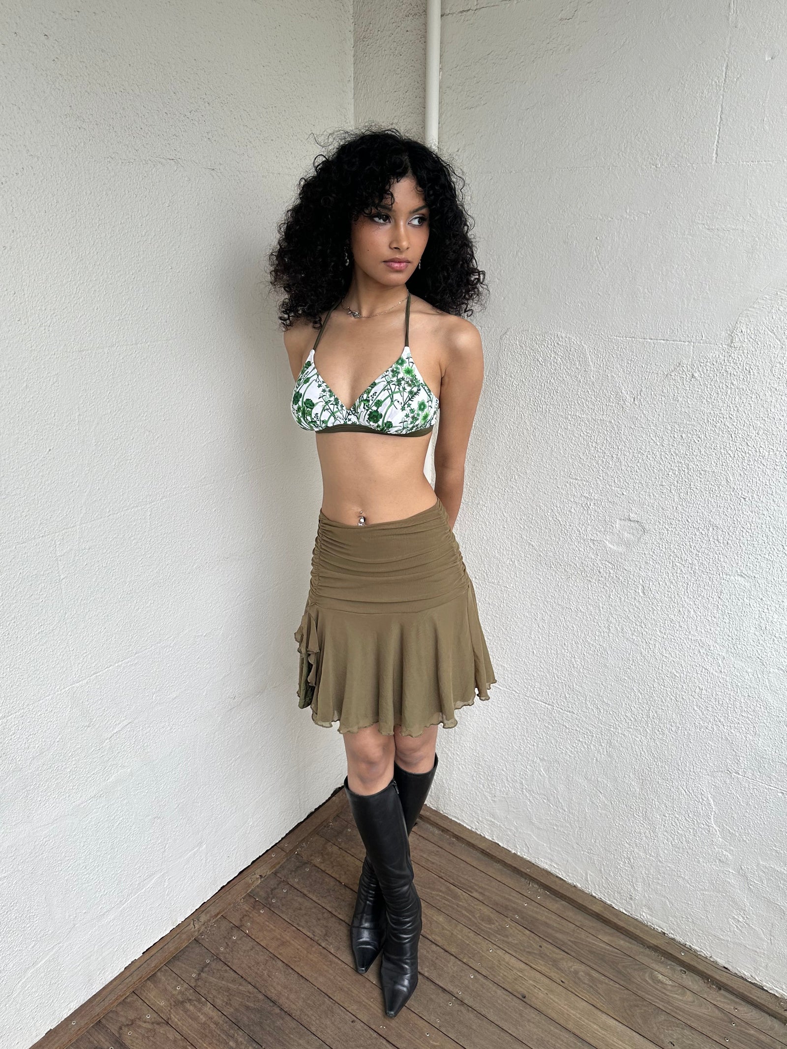 Woman Dressed in Y2K 00s White and green floral bikini top with a white base and green and khaki floral print throughout.