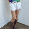 Woman wearing a Y2K 00s White lace bloomer shorts a festival classic. Delicate layered lace detailing with bow detail. 