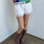 Woman wearing a Y2K 00s White lace bloomer shorts a festival classic. Delicate layered lace detailing with bow detail. 