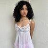 Woman Dressed in Y2K 00s White lace cami with a babydoll silhouette and fully sheer finish. 
