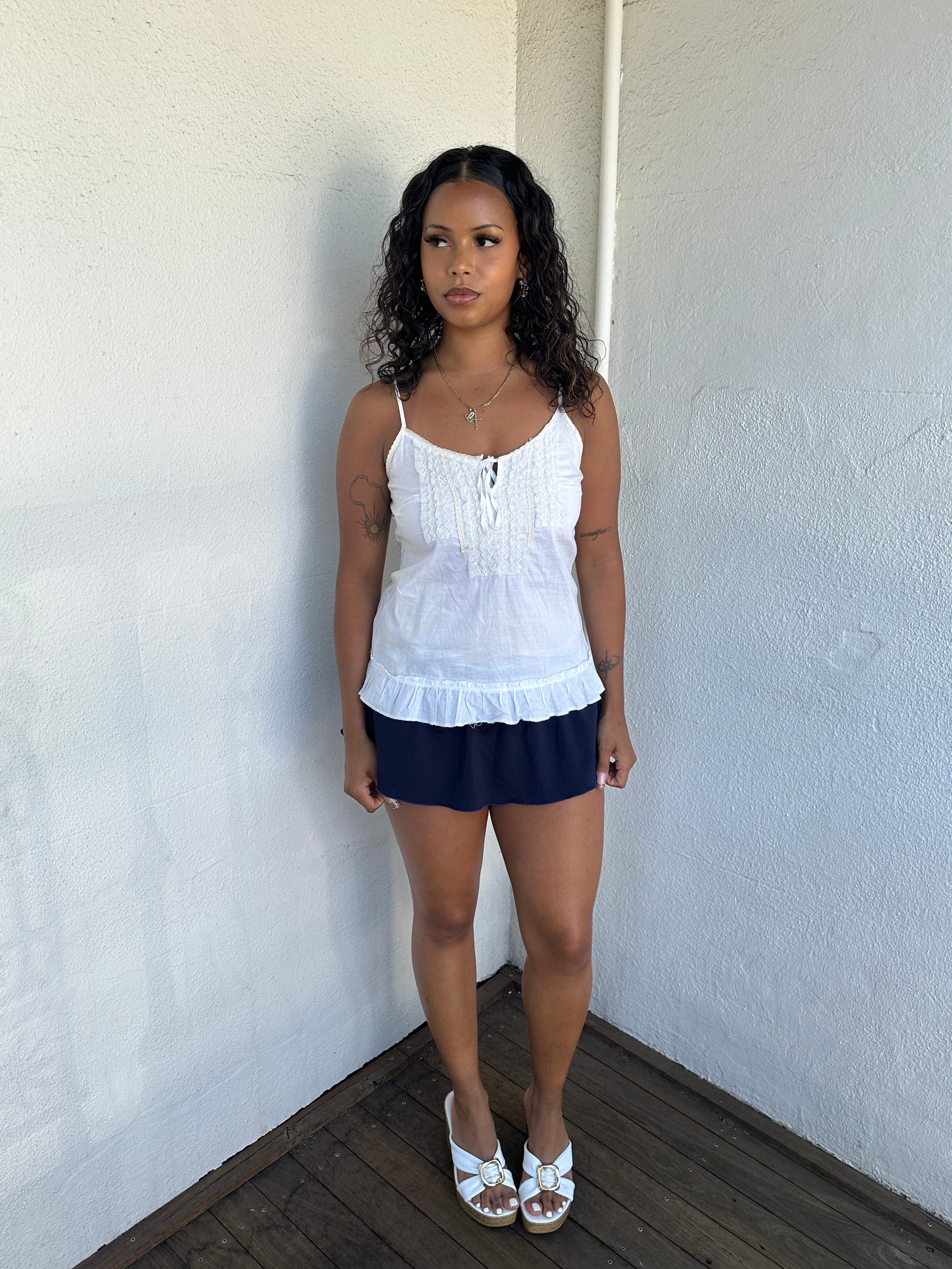 Woman Dressed in Y2K 00s White light cotton cami with a soft, breathable feel and relaxed silhouette. 