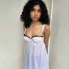 Woman Dressed in Y2K 00s White polkadot babydoll dress featuring a white base with classic polkadot detailing 