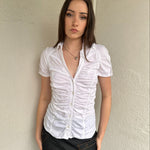 Women wearing a 00s Y2K White ruched textured shirt featuring gathered detailing through the body for a fitted look.