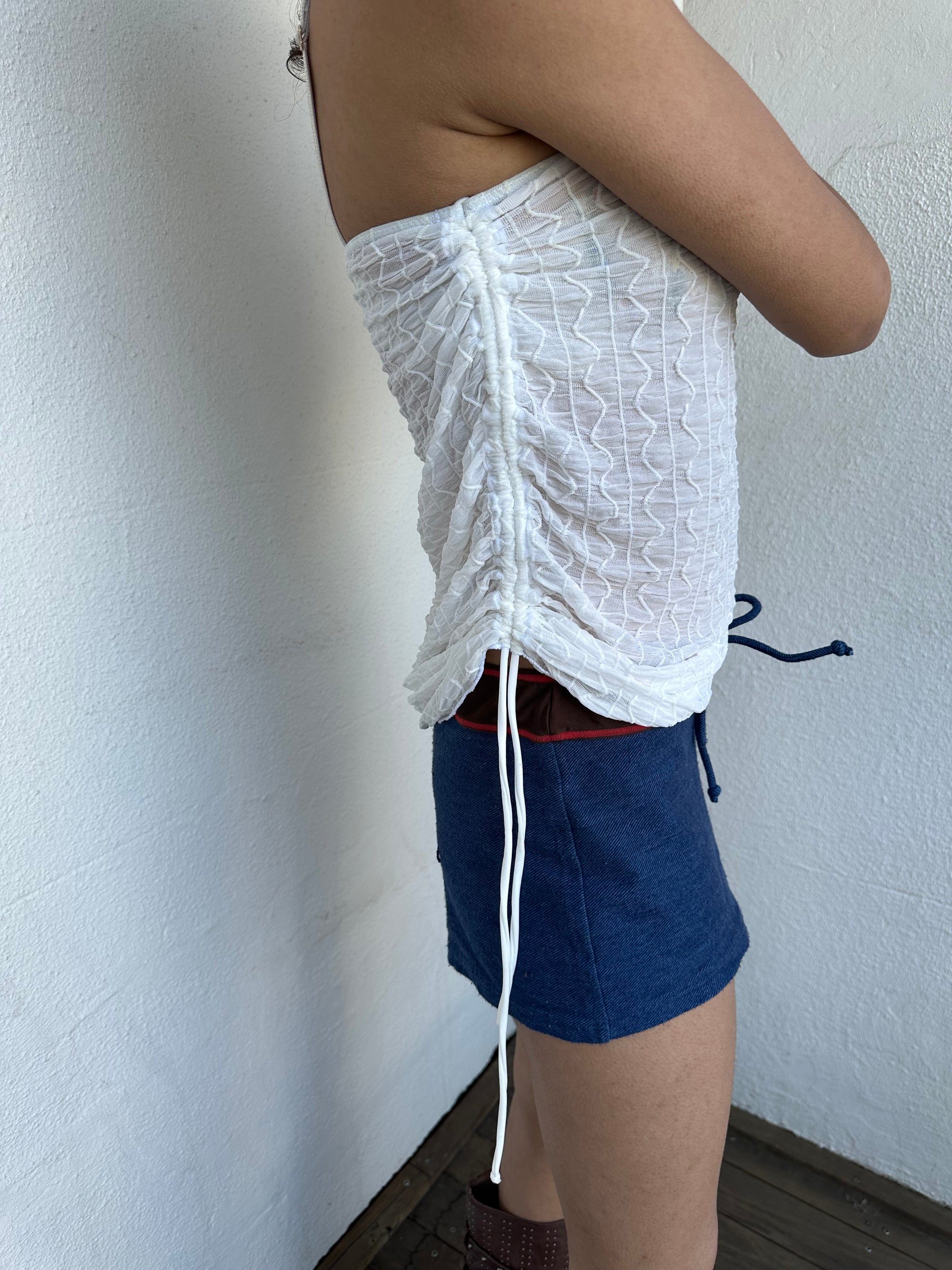 Woman wearing a Y2K 00s white mesh side drawstring strapless top