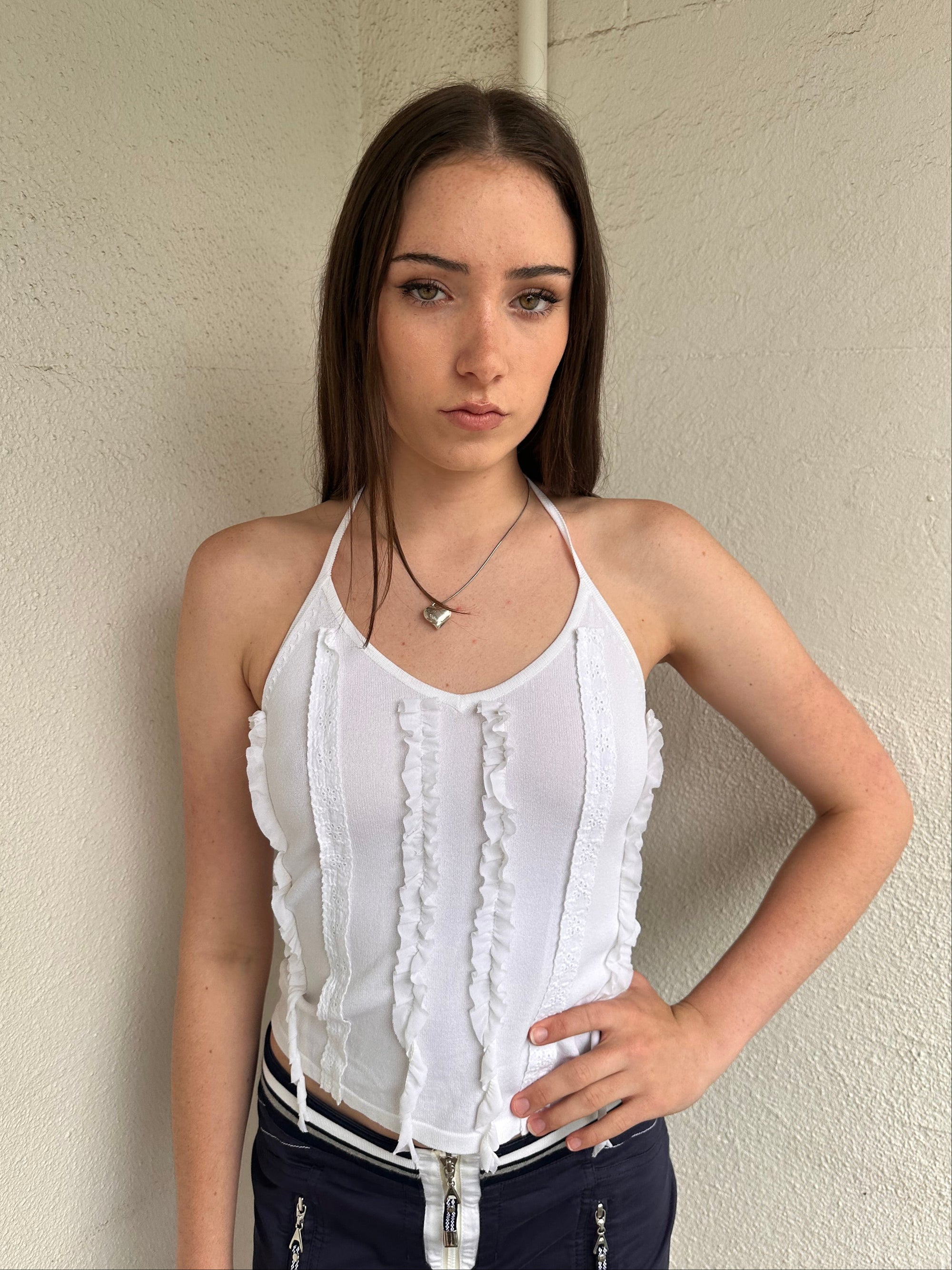 Woman wearing a Y2K 00s white ruffle front halter top 