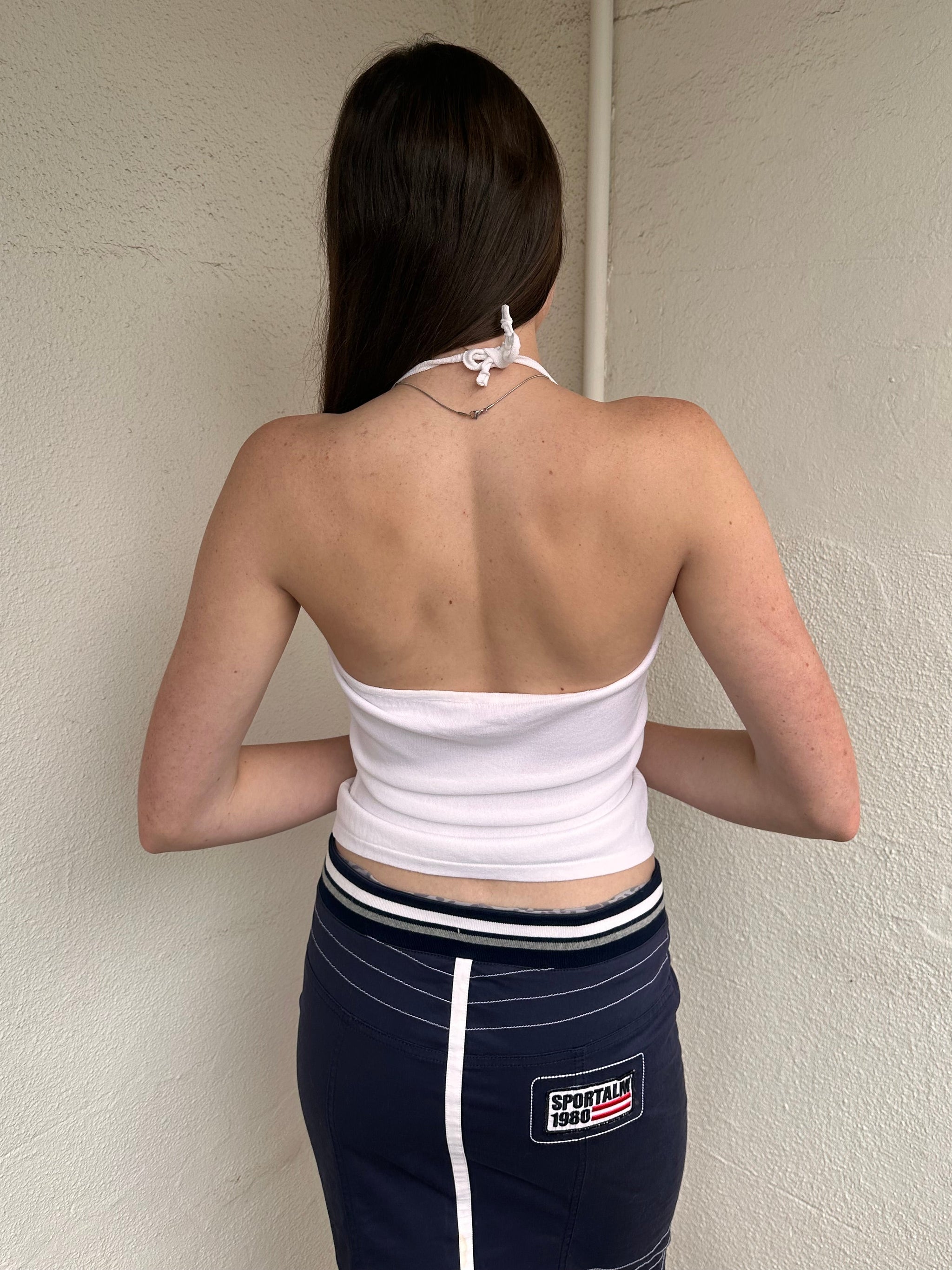 Woman wearing a Y2K 00s white ruffle front halter top 