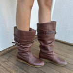 Woman wearing a Y2K 00s Y2K scrunched faux leather boots bring major Bratz energy with silver studded straps