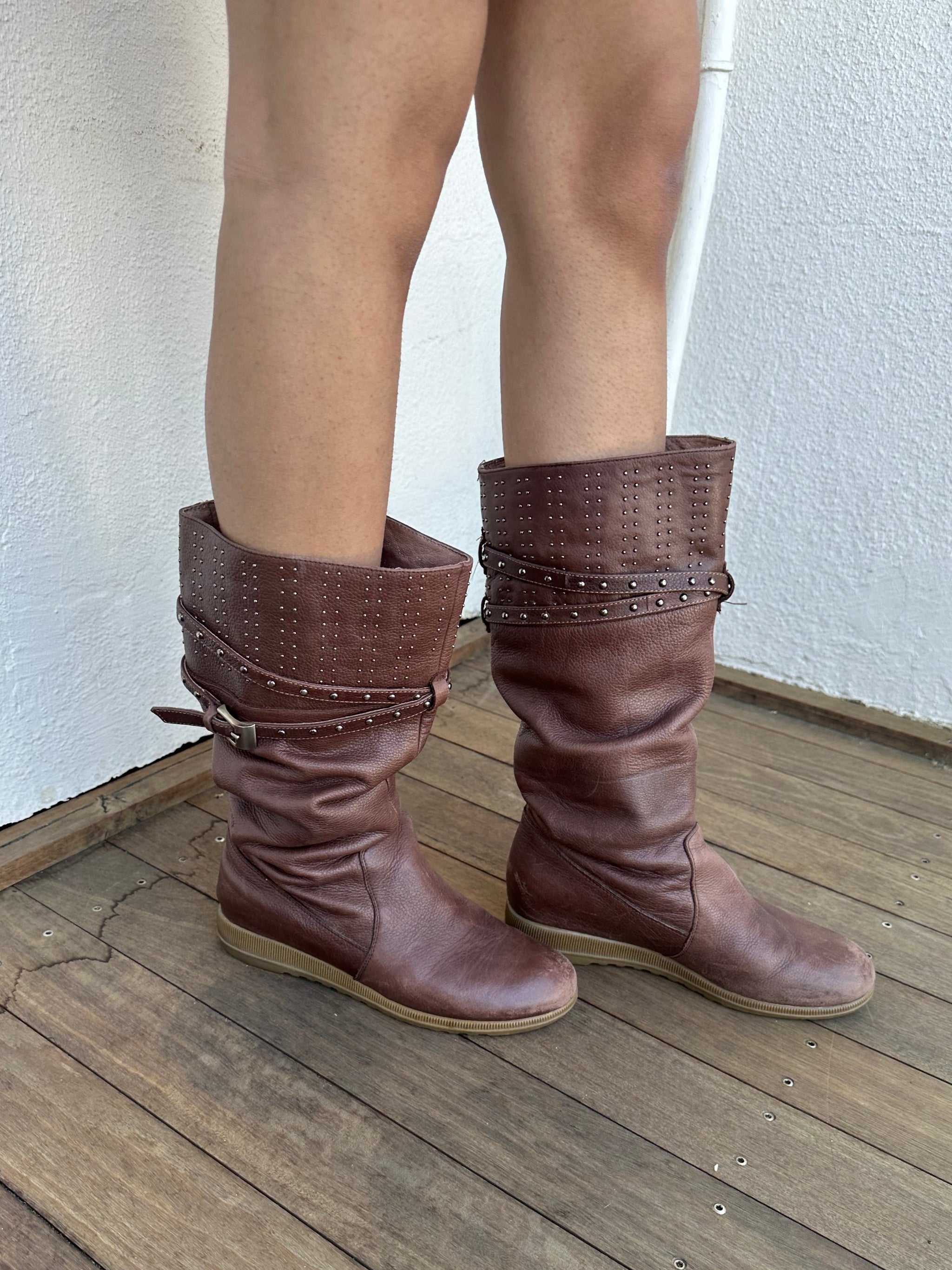 Woman wearing a Y2K 00s Y2K scrunched faux leather boots bring major Bratz energy with silver studded straps