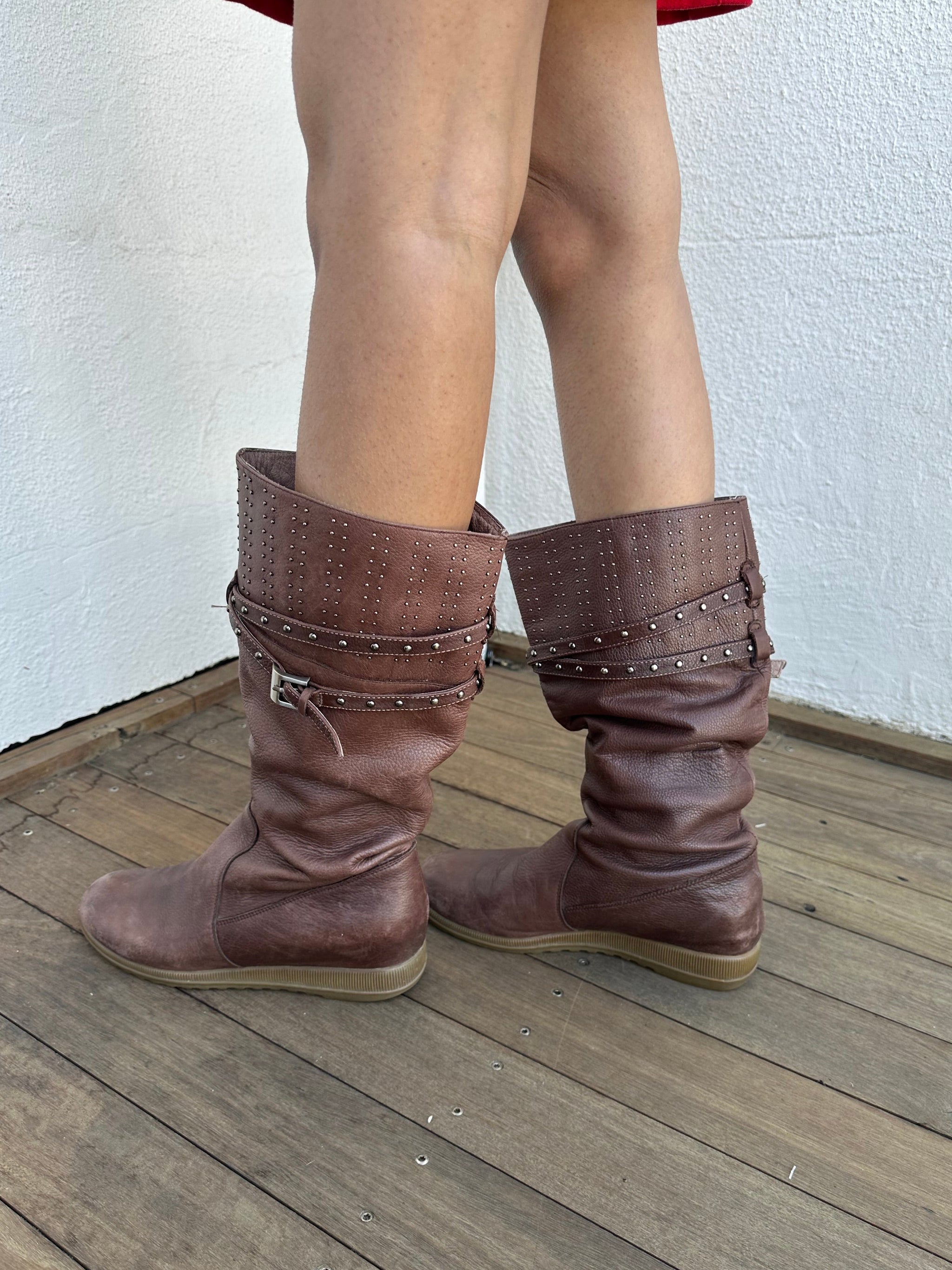 Woman wearing a Y2K 00s Y2K scrunched faux leather boots bring major Bratz energy with silver studded straps
