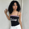 Woman Dressed in Y2K 00s Y2K sporty black graphic cami featuring pink and white “Desirable” printed across the front.