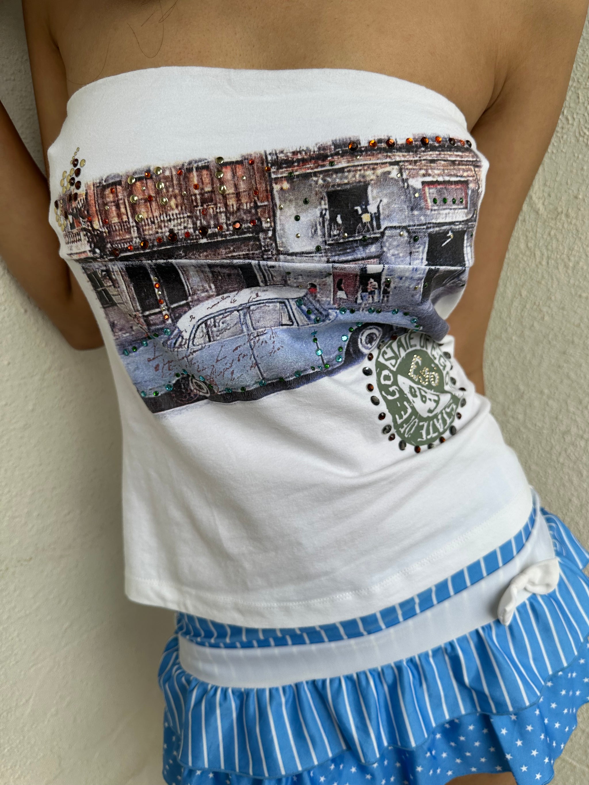 Woman Dressed in Y2K 00s Y2K white graphic tube top featuring a car graphic print design on a white background. 