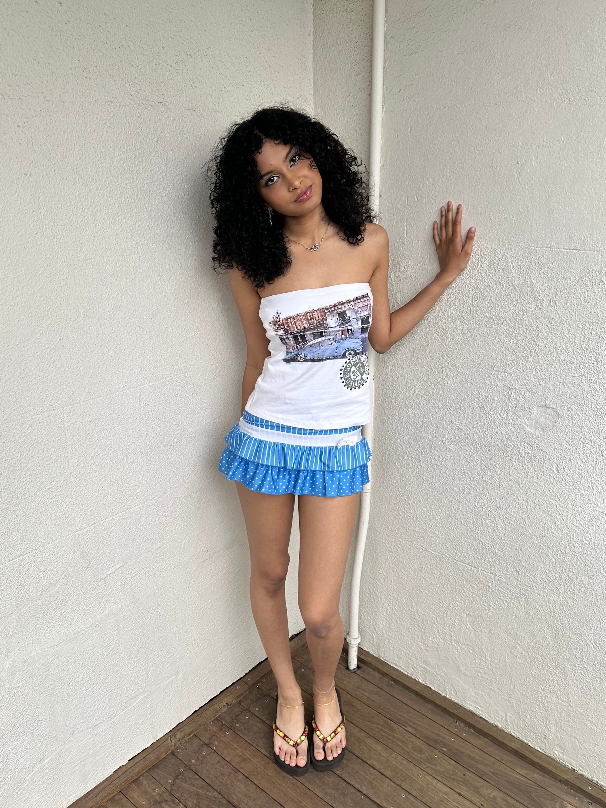 Woman Dressed in Y2K 00s Y2K white graphic tube top featuring a car graphic print design on a white background. 