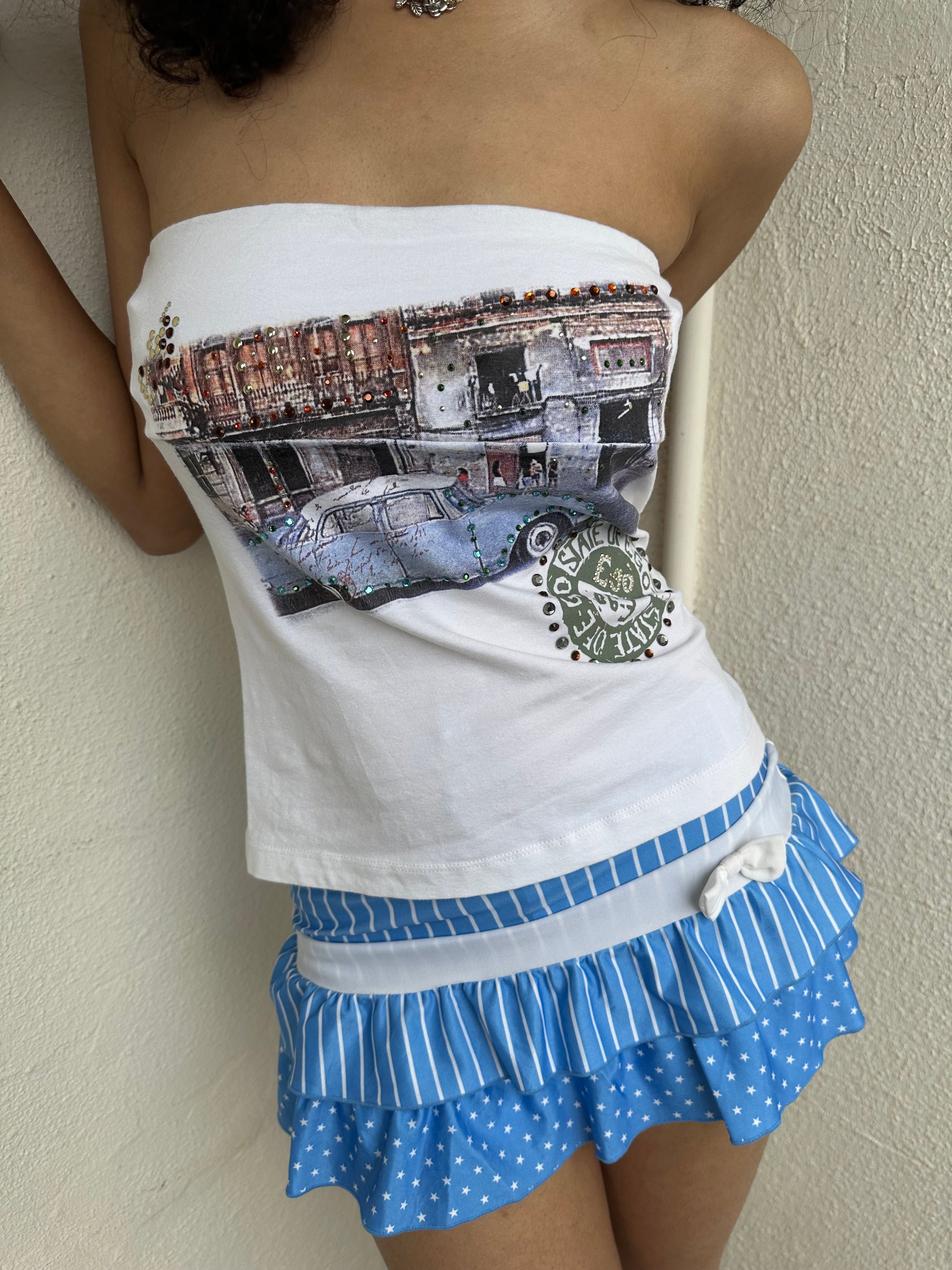 Woman Dressed in Y2K 00s Y2K white graphic tube top featuring a car graphic print design on a white background. 