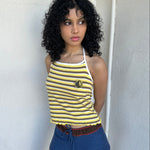 Women wearing a 00s Y2K Elle yellow, white and brown stripe halter top featuring a flower rosette detail on the front.