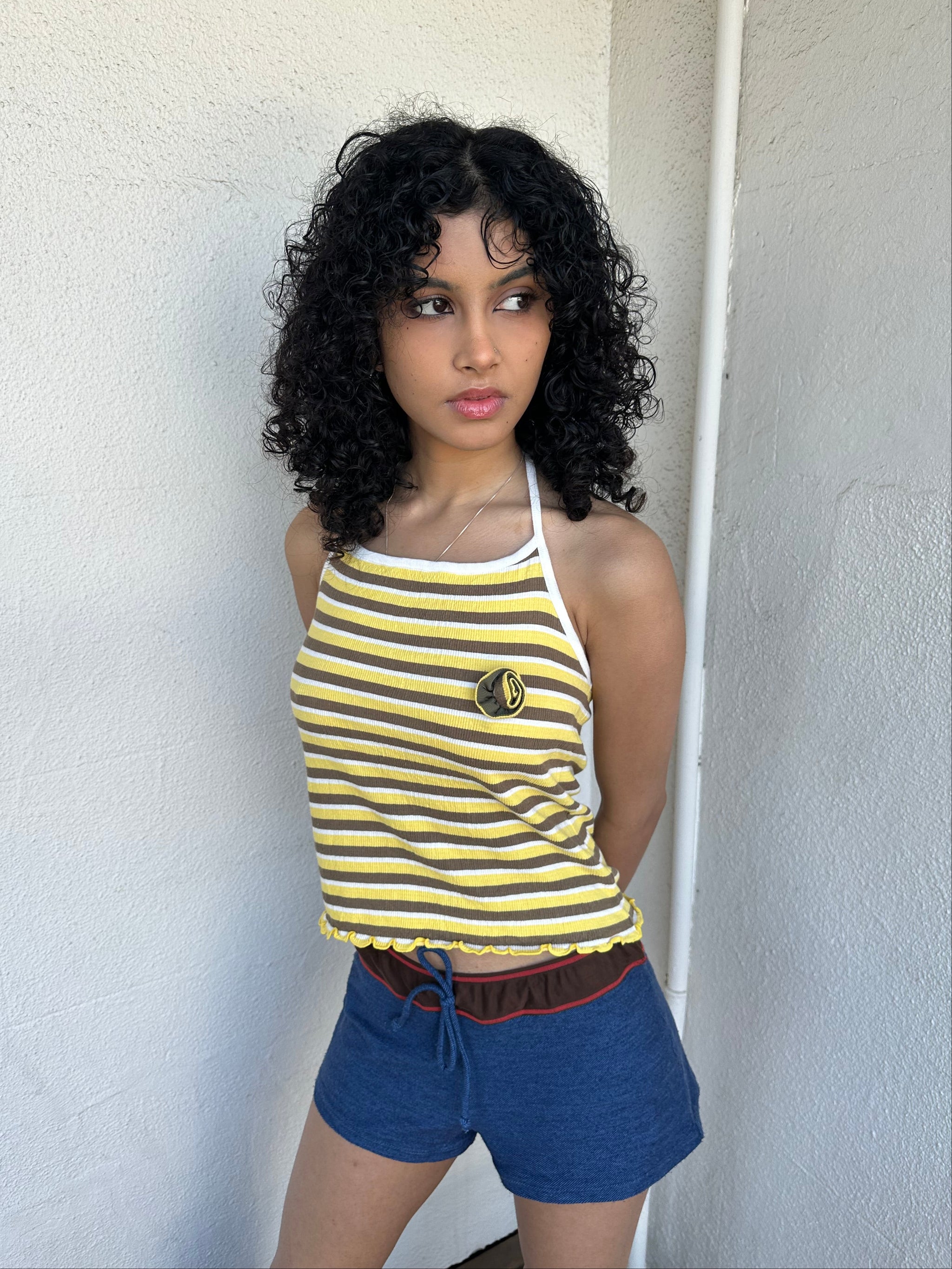 Women wearing a 00s Y2K Elle yellow, white and brown stripe halter top featuring a flower rosette detail on the front.