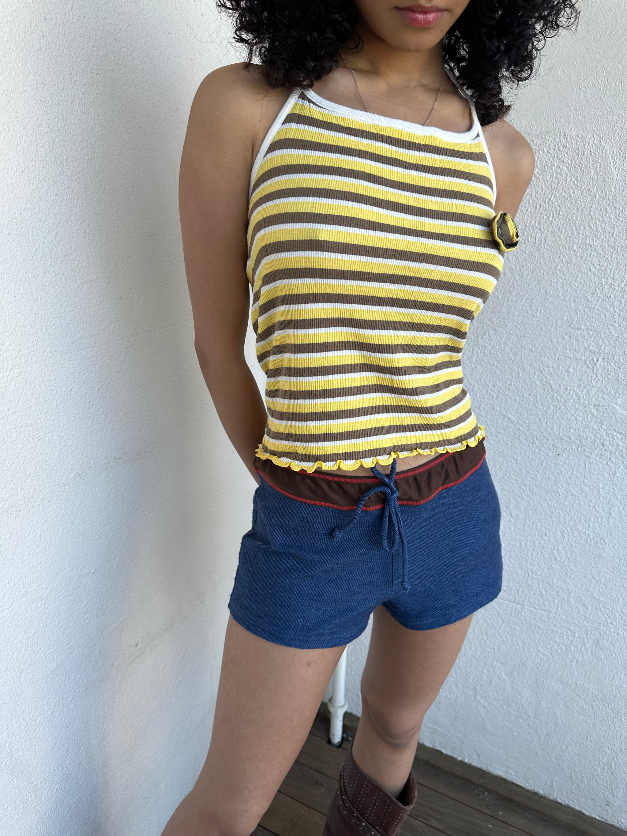 Women wearing a 00s Y2K Elle yellow, white and brown stripe halter top featuring a flower rosette detail on the front.